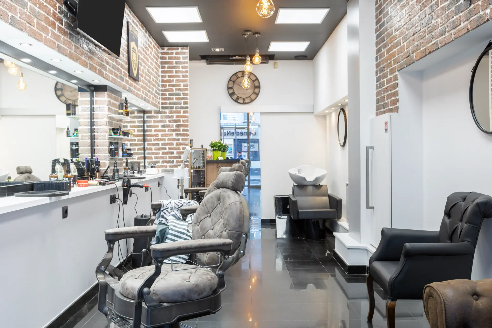 Vue complète de l'intérieur — fauteuils, bac à shampoing et horloge vintage